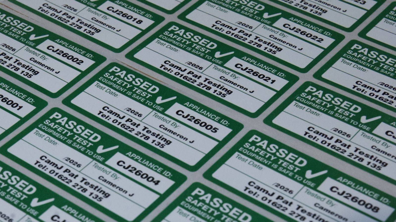 Serialized compliance sticker applied cleanly to an asset pass tag bracket.